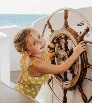 a young girl plays captain on a ship, insured with cruise travel insurance 