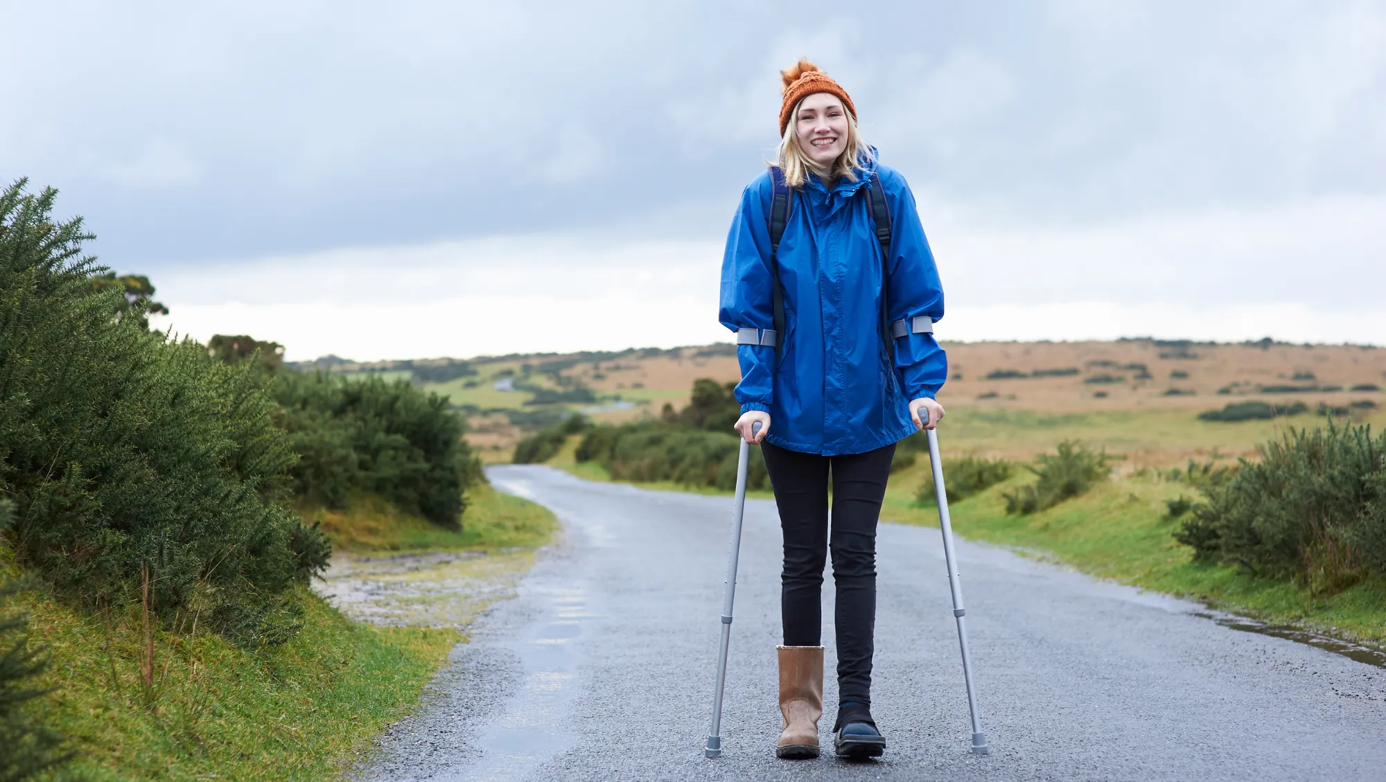 a female traveler uses crutches on a scenic walk after going to the hospital on vacation