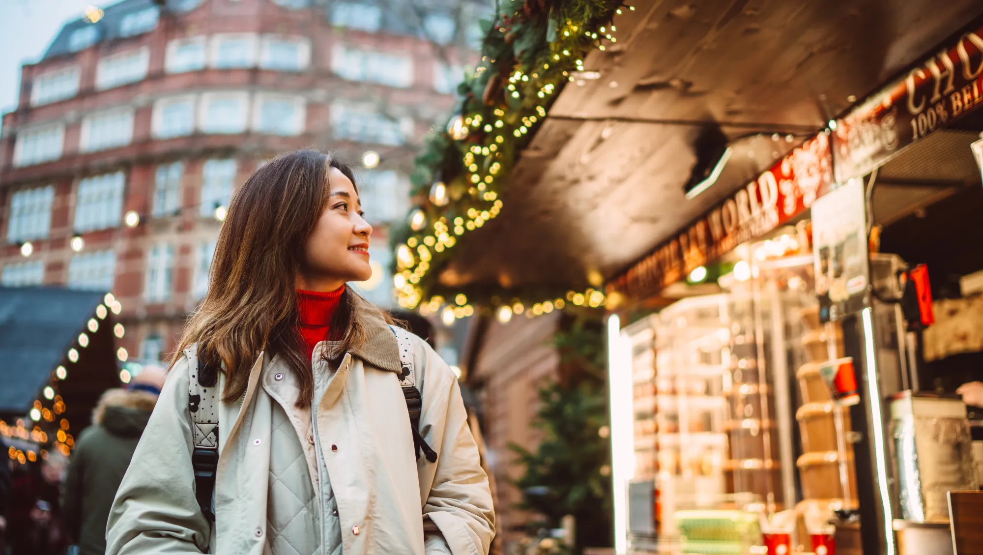 a woman walks through a festive Christmas market, hoping to avoid theft on vacation