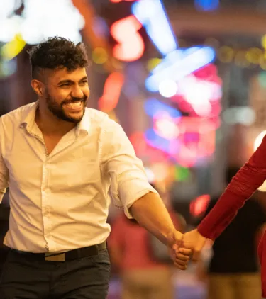 a young couple holds hands and explores the city's nightlife, insured with travel insurance for Las Vegas