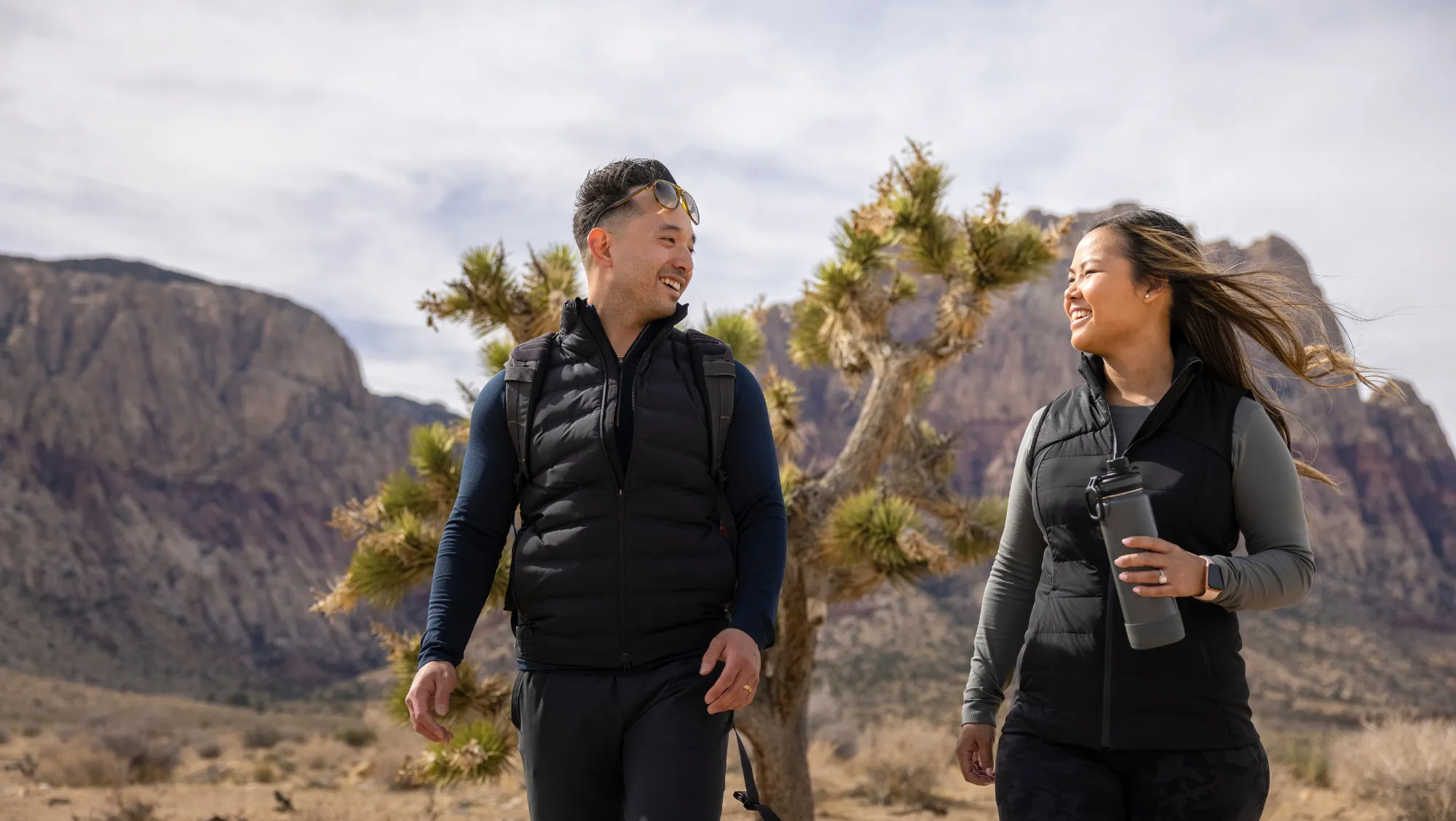 a young couple hikes in the desert in Nevada, after researching, "How much is travel insurance?"