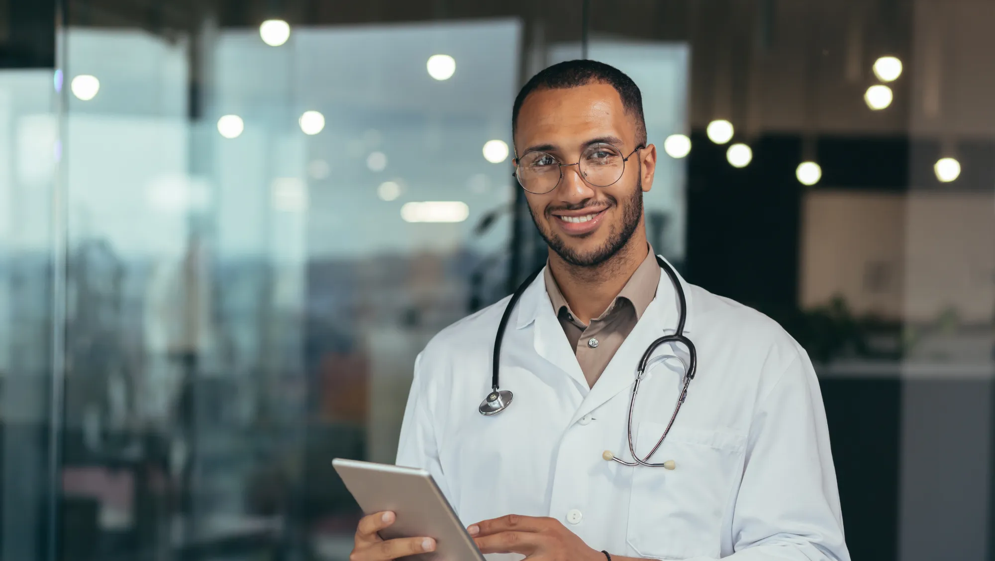 a Middle Eastern doctor holds a tablet, helping those who need to go to the hospital on vacation