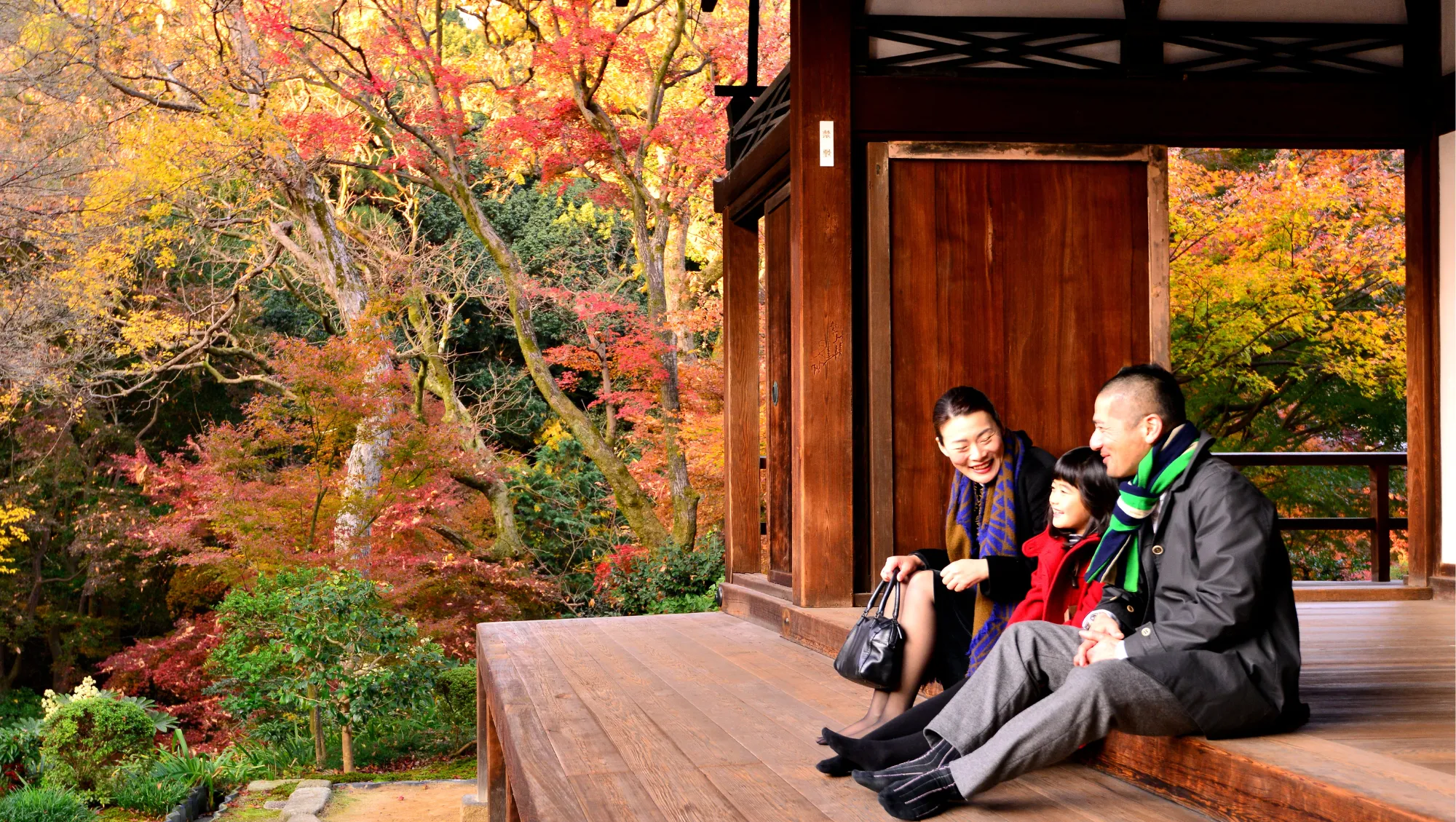 a family sits in a Japanese temple in Autumn, hoping to avoid going to the doctor on vacation