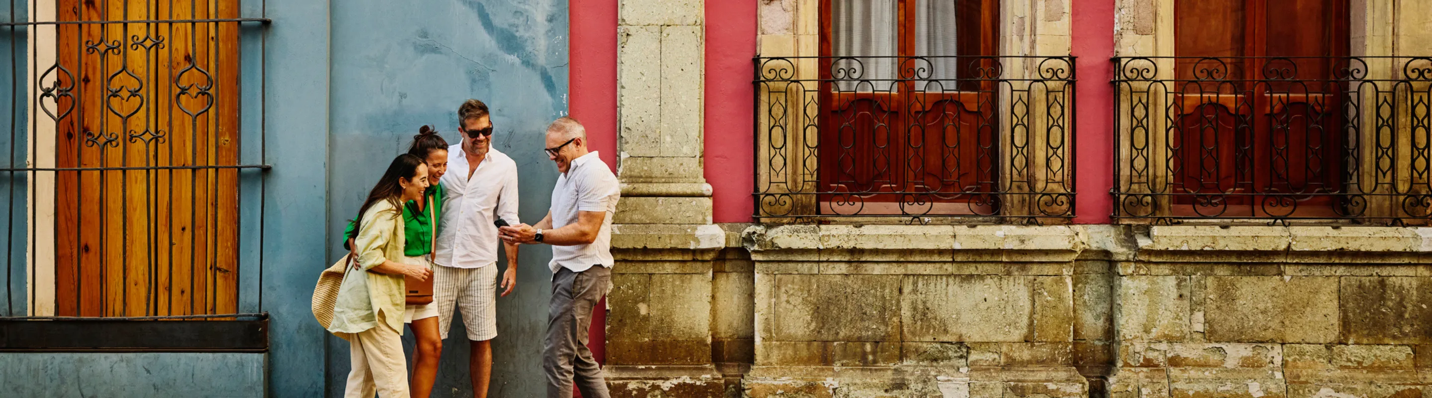 a group of friends with travel insurance for COVID-19, looking at their maps on vacation nearby historic buildings