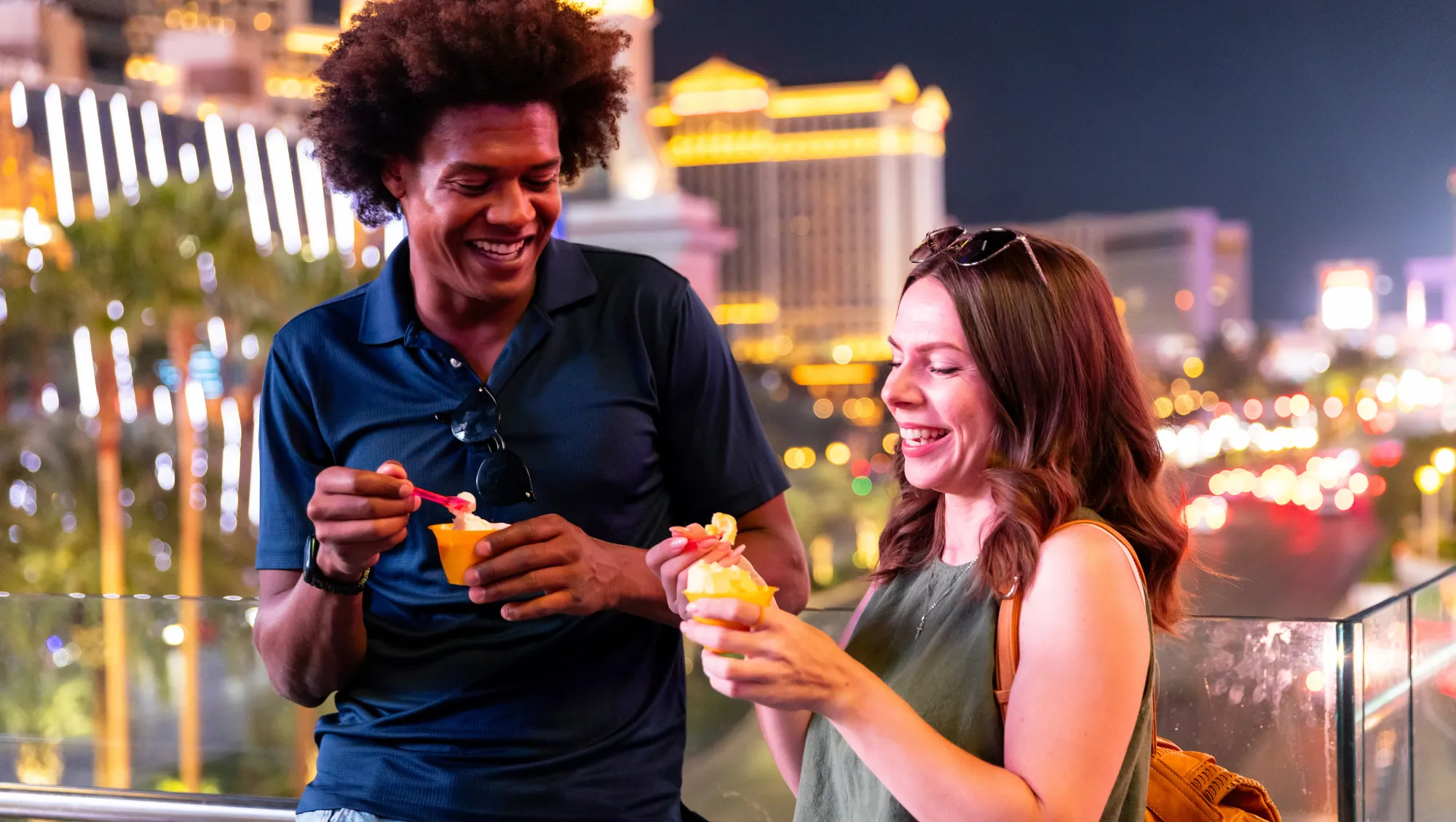two young friends eat ice cream outside in Las Vegas, hoping to avoid theft on vacation