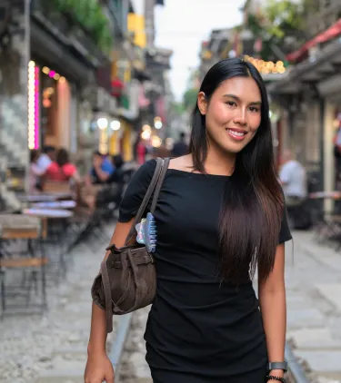 a woman with travel insurance for Vietnam walks along Hanoi Train Street, lined with cafés and traditional buildings