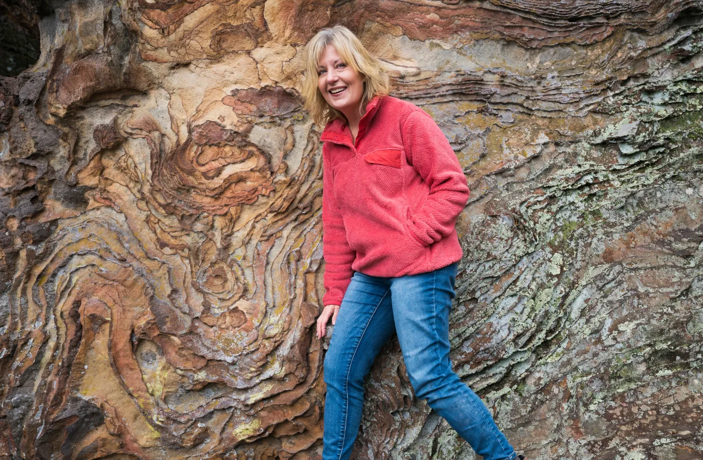 a female hiker stands on Shawnee National Forest rock formations, insured with travel insurance for Illinois