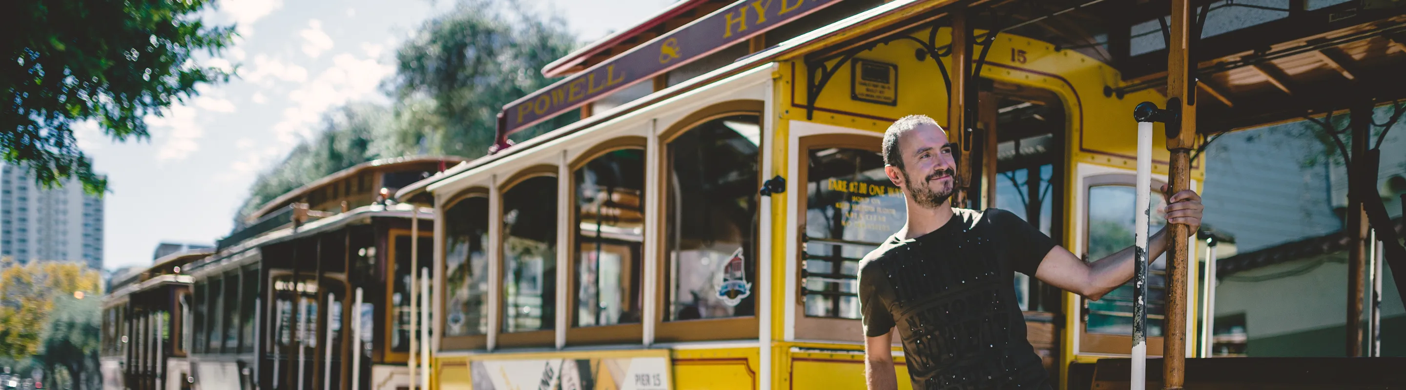 a man catches a yellow cable car in downtown San Francisco, insured with travel insurance for California