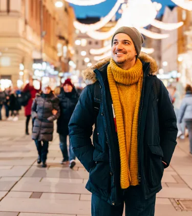 a man walking through Graben, Vienna, as night falls, insured with travel insurance for Austria 