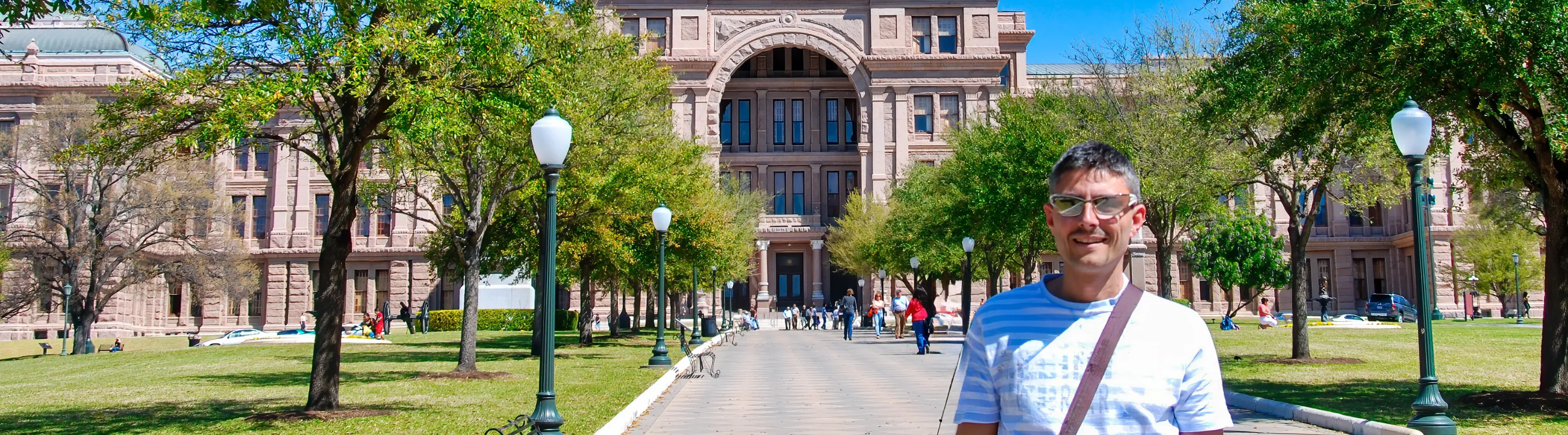 a middle-aged man with travel insurance for Texas stands in front of the Texas State Capitol in Austin 