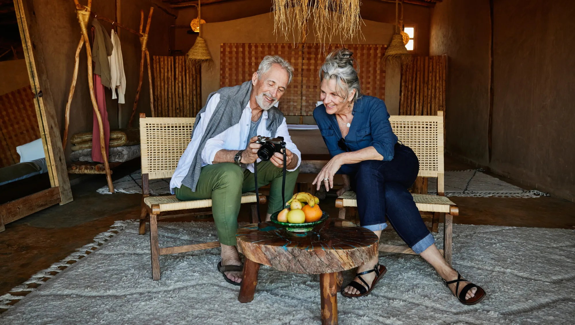 an older couple looks at their camera in their hotel room, hoping to avoid theft on vacation