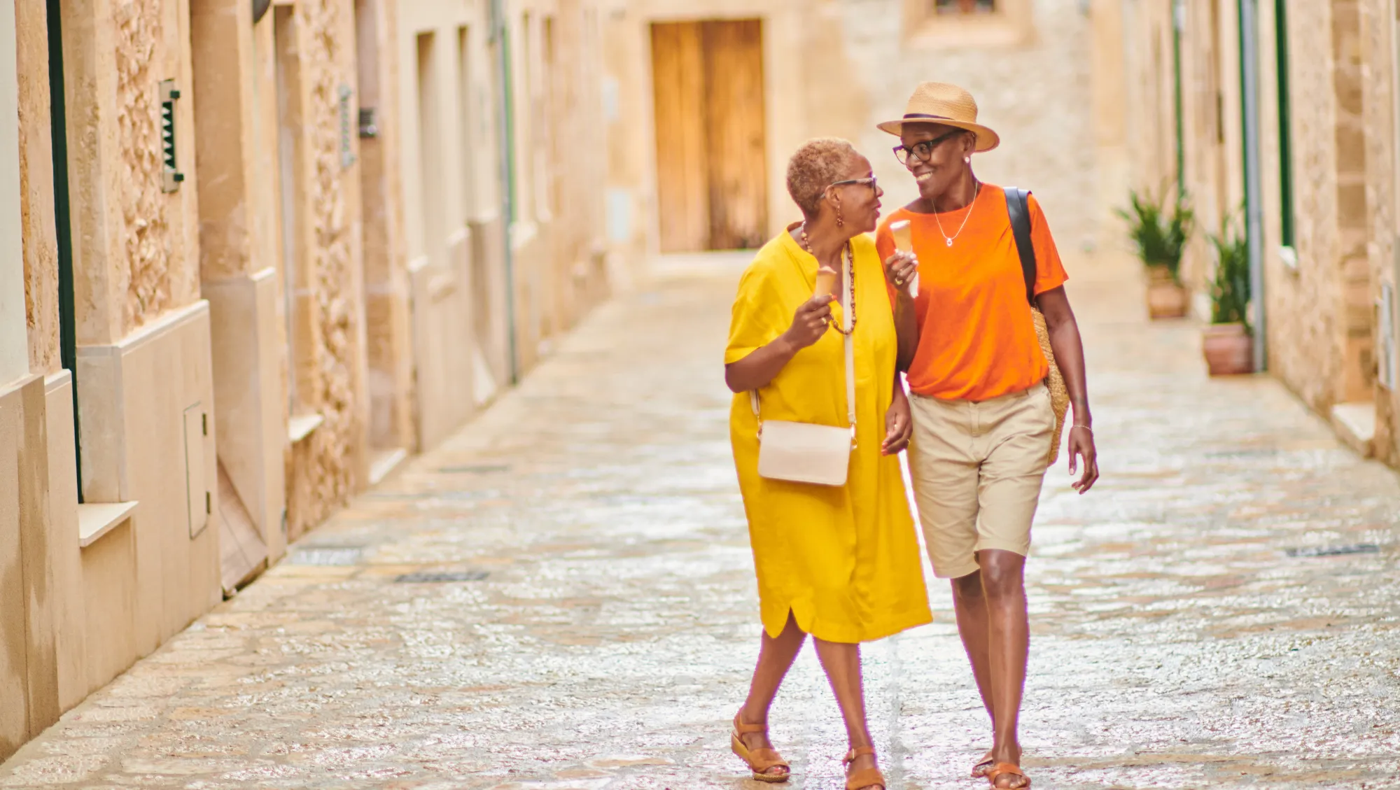 a senior couple embraces as they walk down an alley in Spain on vacation after reading our LGBTQ travel tips