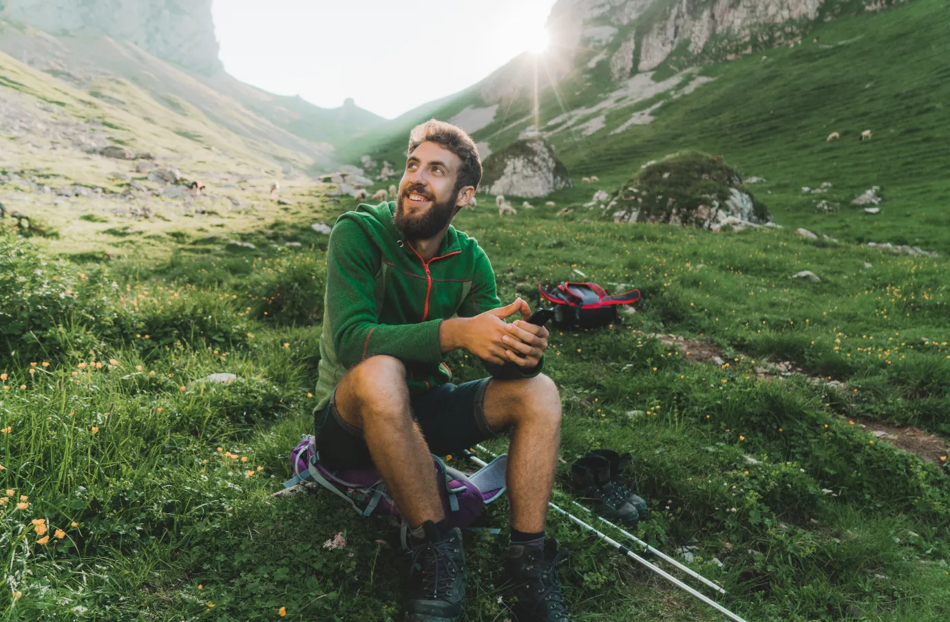 a male solo hiker rests in the mountains, insured with travel insurance for Switzerland