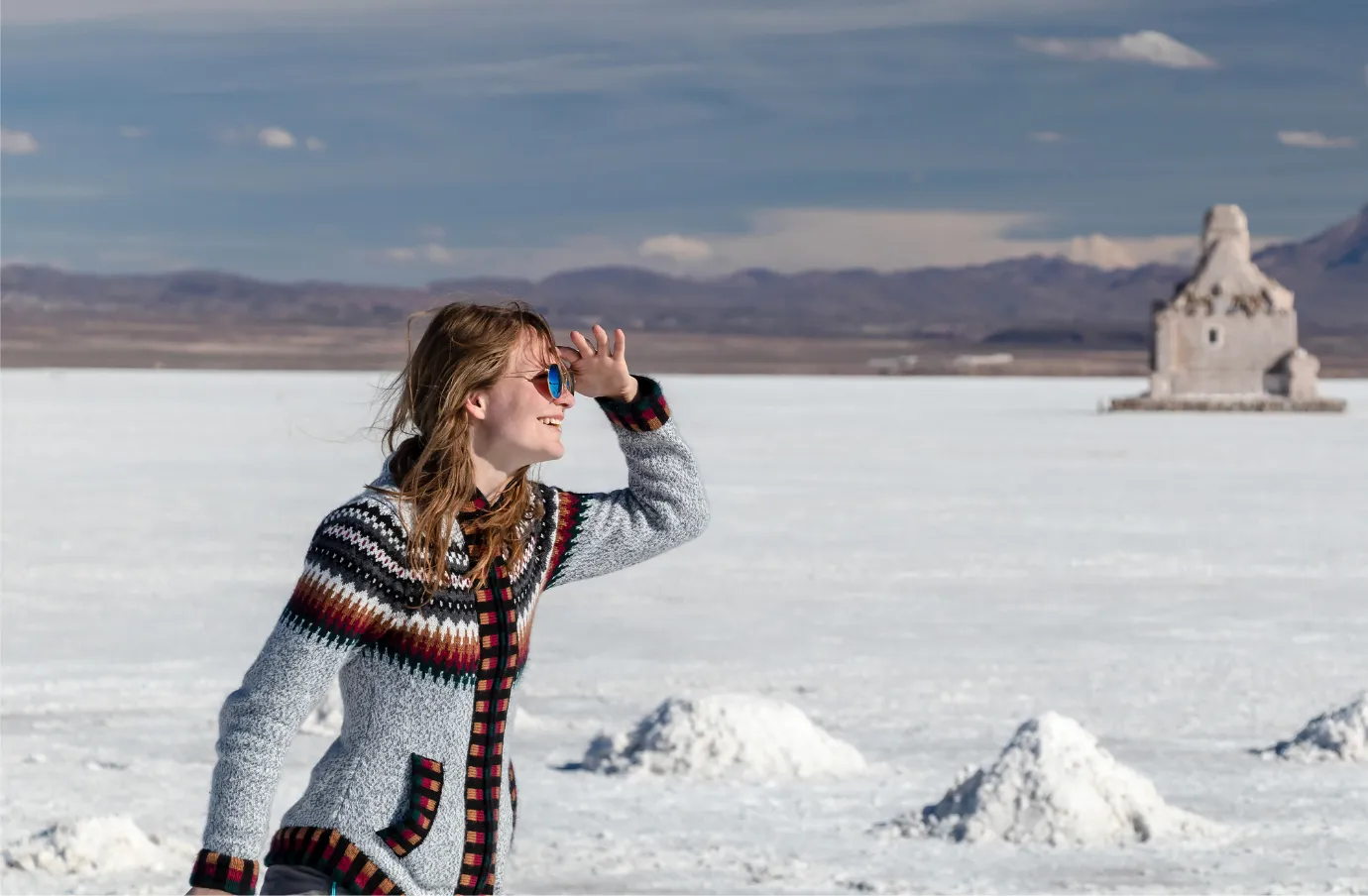 a woman stands in the salt flats in Bolivia in warm clothes, insured with travel insurance for South America