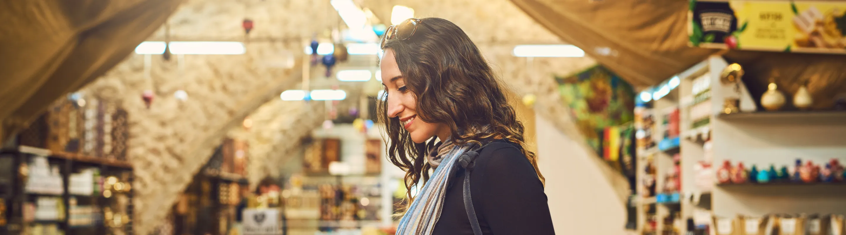 a woman browses spices at a market, insured with travel insurance for Israel
