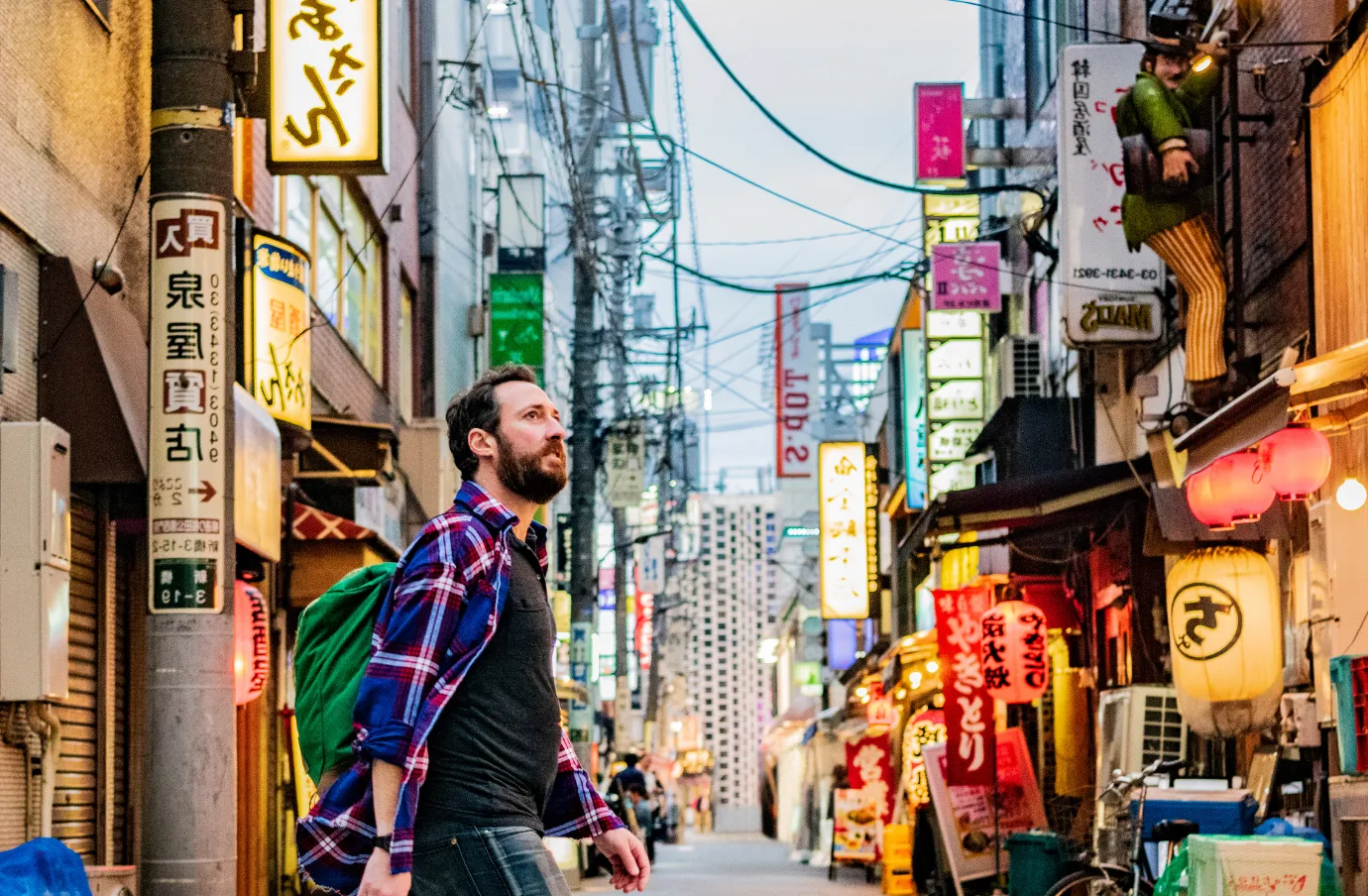 a young man crosses a side street in Tokyo, Japan, insured with travel insurance for Japan