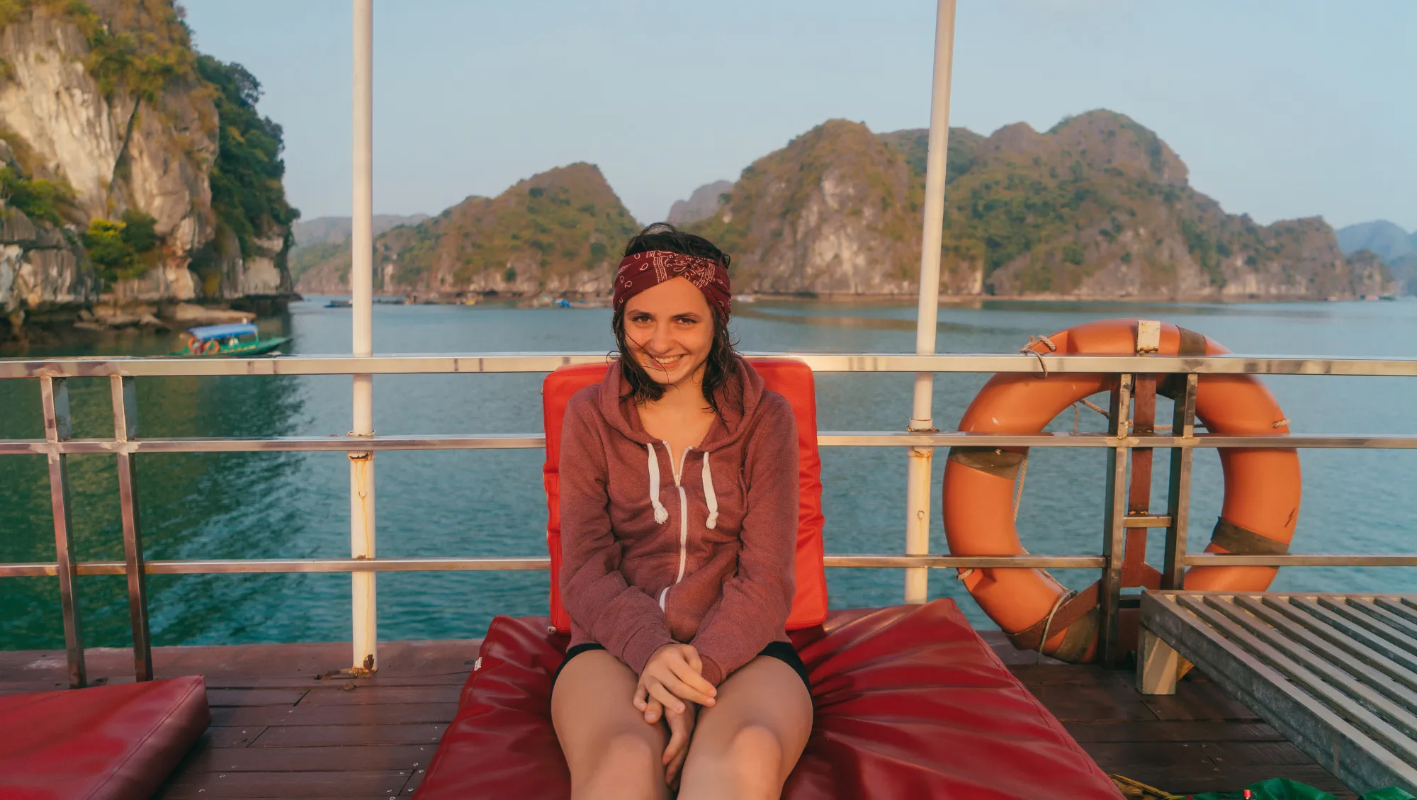 a woman relaxes on the deck of a cruise boat in Ha Long Bay after reading our cruise safety tips