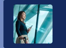 a woman a phone and suitcase in an airport, highlighted in the Travelex Insurance newsroom