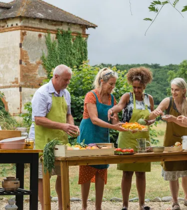 middle-aged travelers take a cooking class in the French countryside, insured with travel insurance for France 