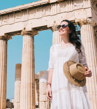 woman with travel insurance for Greece touring the Parthenon in Athens, Greece 