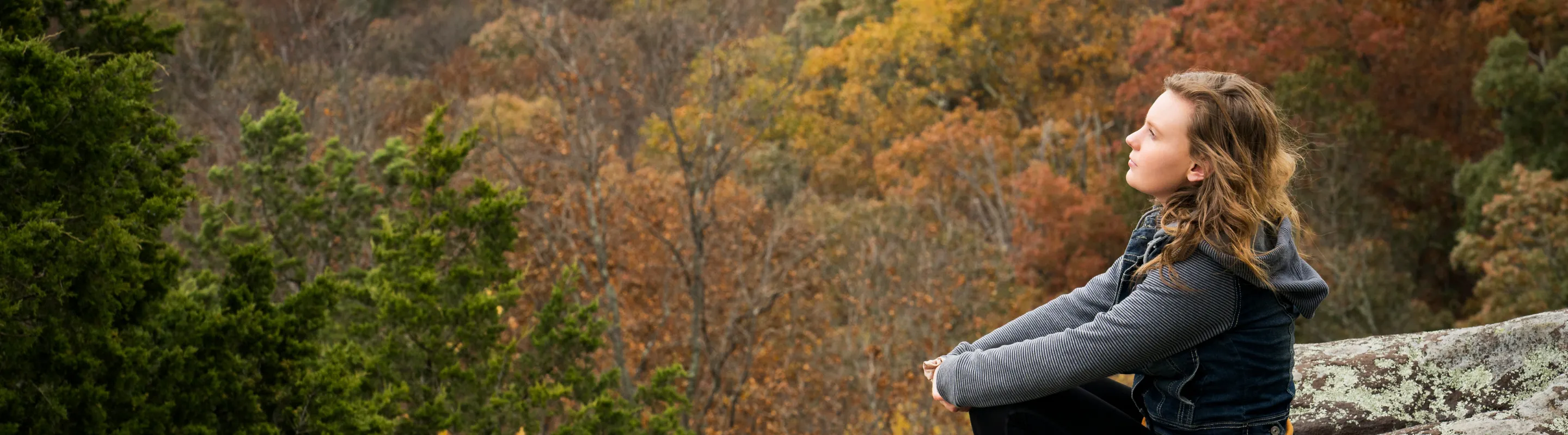 a woman sits on a rock while hiking the Garden of Gods, insured with travel insurance for Illinois