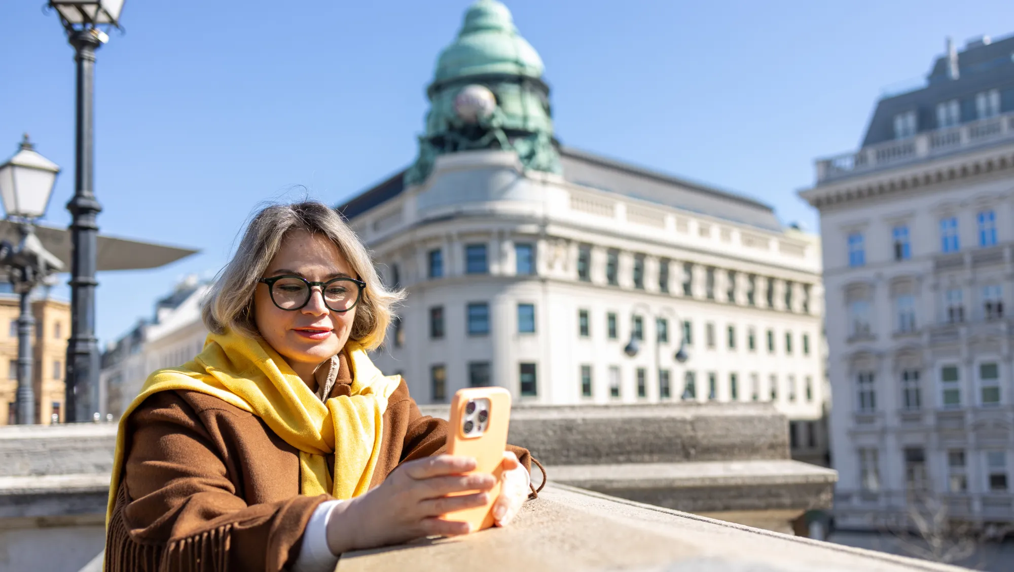 a woman uses the travel app on her phone in Vienna's historic center 