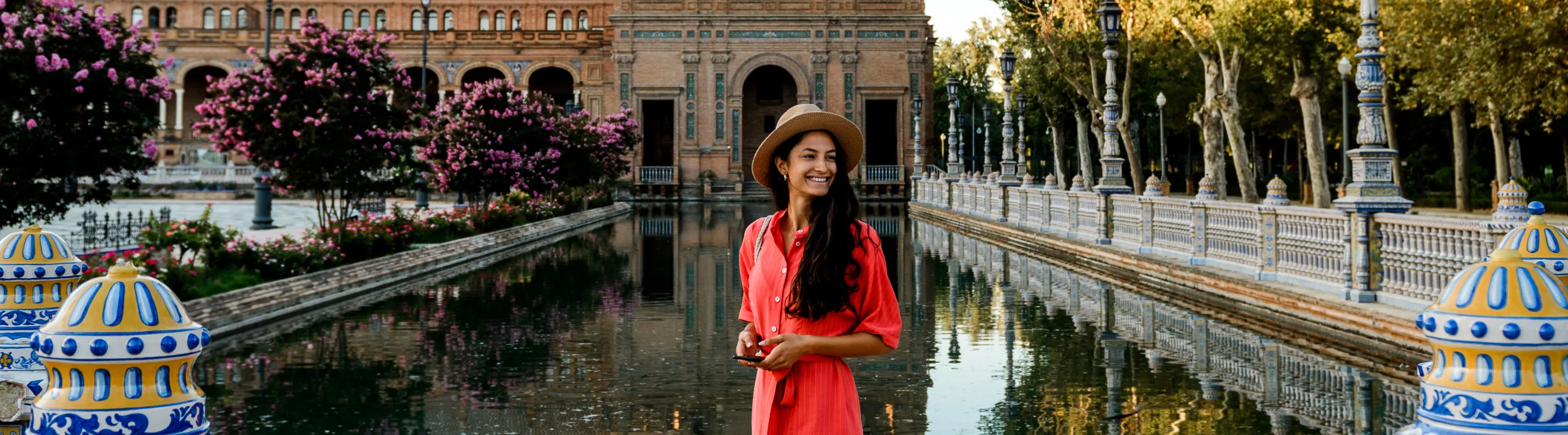 a young woman in a dress visits Plaza de Espana, Seville, insured with travel insurance for Spain