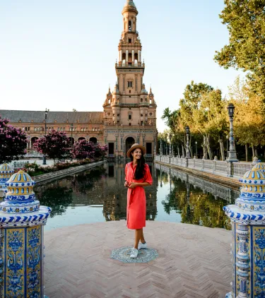 a young woman in a dress visits Plaza de Espana, Seville, insured with travel insurance for Spain
