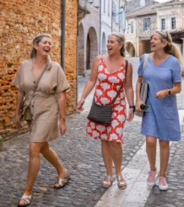 women with travel insurance for France, laughing as they tour a local town in France