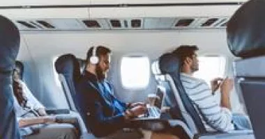 Travelers working and relaxing on a flight