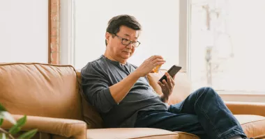 Man looking at prescription medication and holding his smartphone.