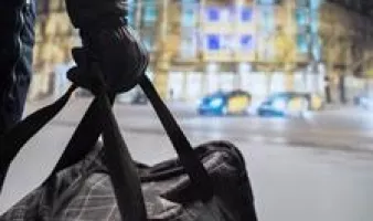 Gloved hand holding a duffel bag