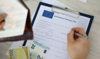 Hand filling out application for Schengen visa