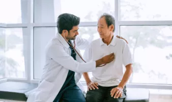 Doctor checking patient&#039;s heart at a travel health care appointment