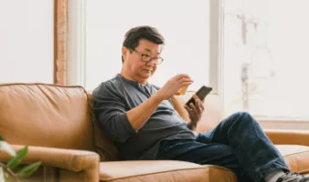 Man looking at prescription medication and holding his smartphone.