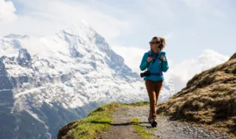 Woman hiking in the mountains in Switzerland, one of the best places to travel as a solo female in the U.S. and abroad.