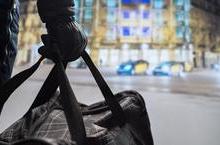 Gloved hand holding a duffel bag