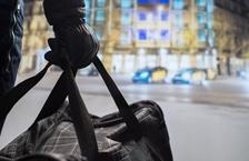 Gloved hand holding a duffel bag