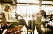 Mother at the airport for travel during pregnancy with her young son.